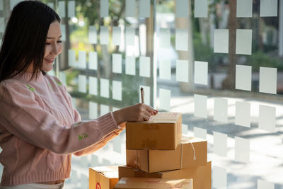Side view of woman holding box