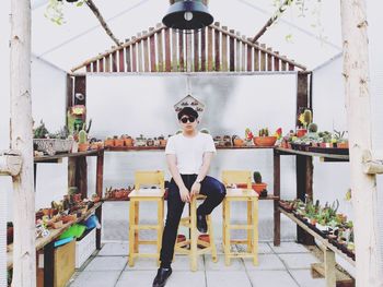 Portrait of man wearing sunglasses sitting in plant nursery