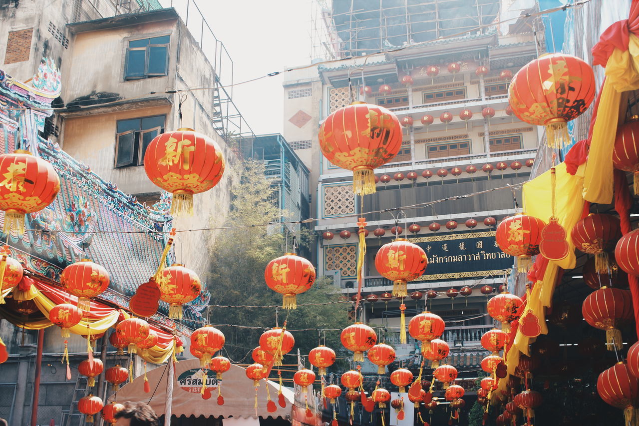 red, orange color, building exterior, built structure, market, architecture, hanging, retail, abundance, large group of objects, outdoors, for sale, market stall, cultures, day, tradition, variation, freshness, celebration, large group of people