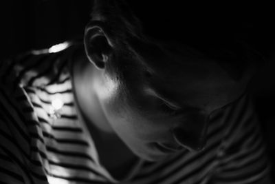 Close-up of teenage boy against black background