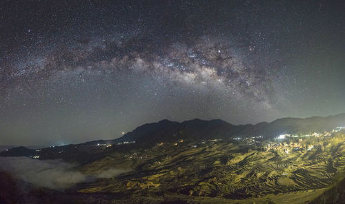 Scenic view of mountains against sky at night