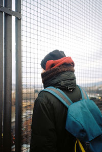 Backpack woman looking through fence