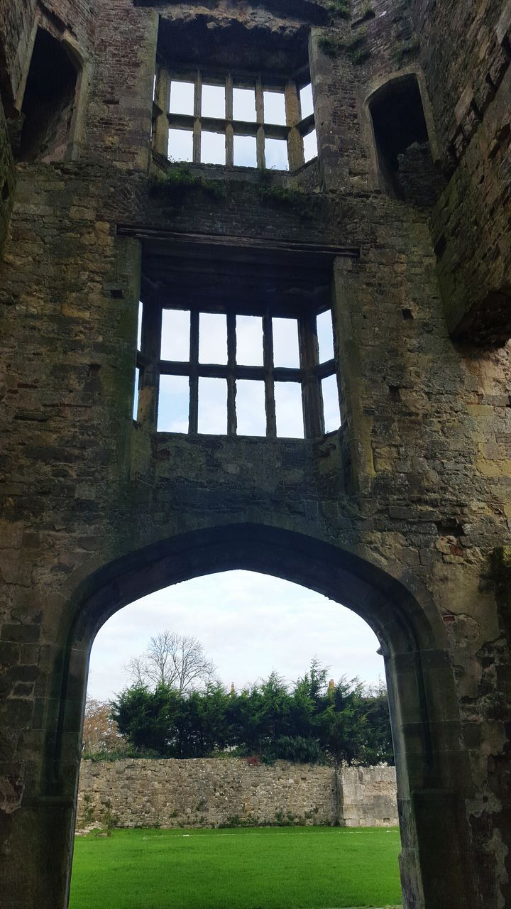 architecture, built structure, arch, building exterior, history, grass, old, window, the past, tree, old ruin, day, building, sky, no people, lawn, low angle view, architectural column, outdoors, abandoned