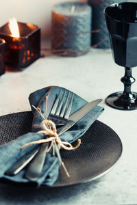 Close-up of cutlery tied with napkin in plate on table