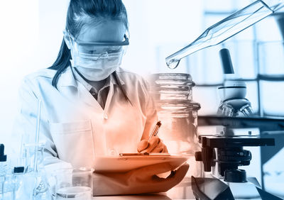 Female scientist writing on clipboard