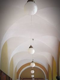 Low angle view of illuminated chandelier hanging on ceiling in building