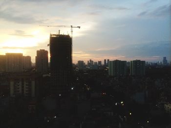 Silhouette of buildings against sky at sunset