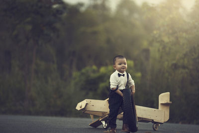 Full length portrait of boy sitting on motorcycle