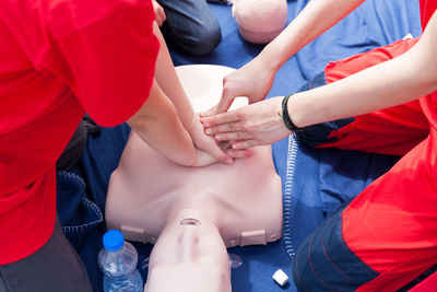 Volunteers giving first aid training with mannequin
