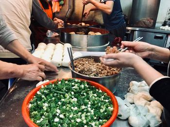 Midsection of men preparing food in commercial kitchen