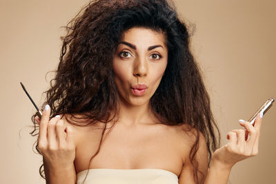 Portrait of smiling young woman applying make-up at home