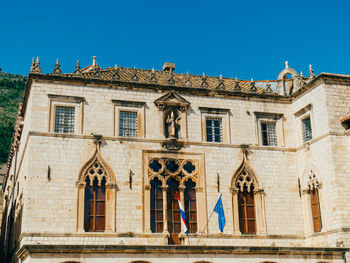Low angle view of old building against clear blue sky