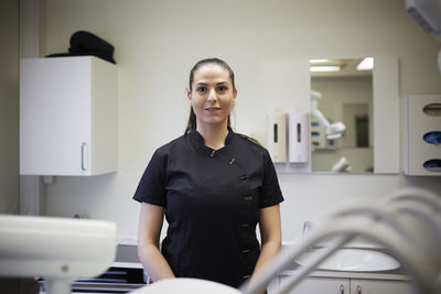 Female dentist standing in office