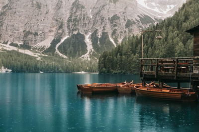 Boat moored on lake by mountain