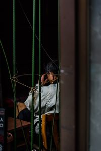 Man standing against curtain at night