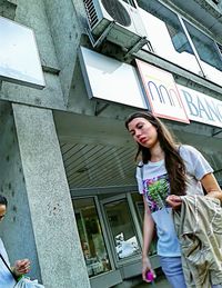 Low angle view of woman standing against building