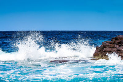 Scenic view of sea against clear blue sky