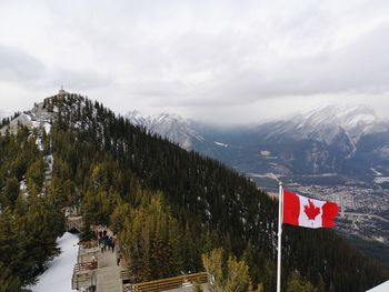 Canadian flag on mountain against sky