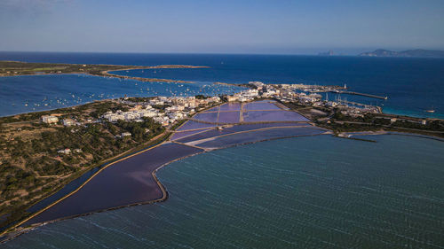 High angle view of city by sea against sky