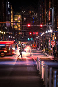 Illuminated city at night with silhouettes.