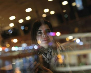 Young woman with illuminated lights at night