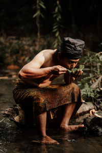 Rear view of man sitting on field