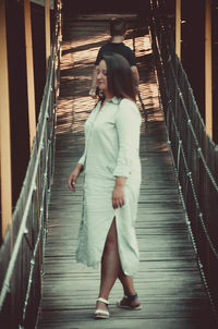 Full length of woman walking on footbridge