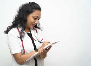 Young woman using smart phone against white background