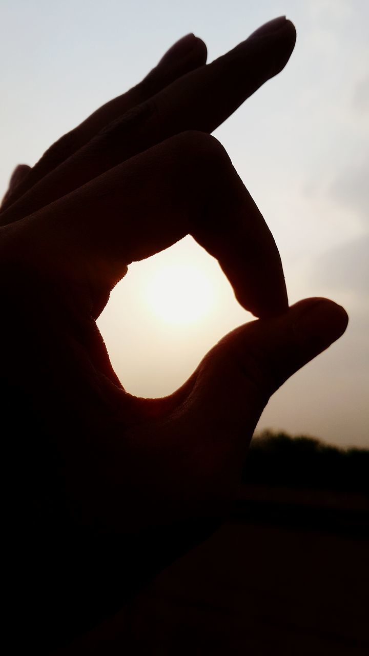 sky, person, silhouette, part of, close-up, low angle view, human finger, cropped, sunset, sunlight, sun, unrecognizable person, nature, outdoors, cloud - sky, focus on foreground, back lit