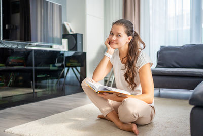 Side view of young woman exercising at home