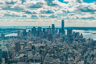 Aerial view of illuminated skyscraper buildings in city at day at high angle