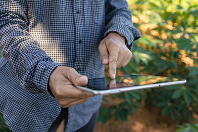 Midsection of man using mobile phone