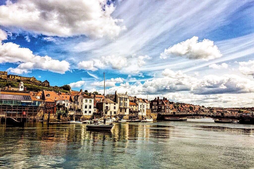 architecture, building exterior, water, built structure, waterfront, sky, cloud - sky, cloud, city, river, residential structure, residential building, house, cityscape, residential district, rippled, cloudy, town, nautical vessel, sea