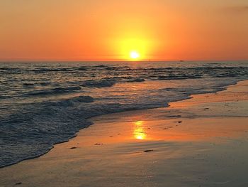 Scenic view of sea against dramatic sky during sunset