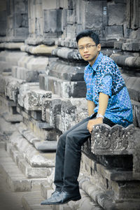 Side view of young man sitting on steps