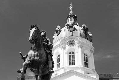 Low angle view of statue against building against sky