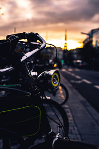 Bicycle on road against sky at sunset