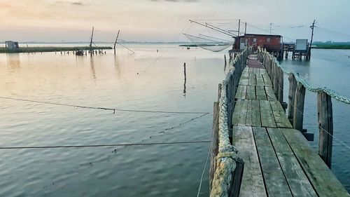 Wooden pier on sea against sky