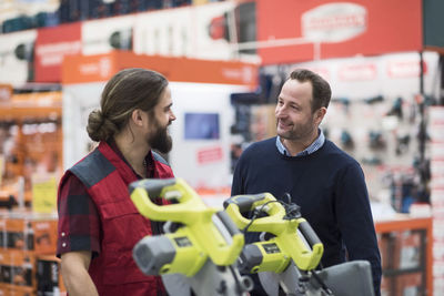 Salesman discussing with male customer in hardware store