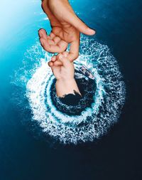 High angle view of hands in water at swimming pool