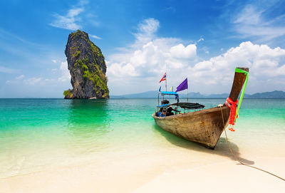 Thai traditional wooden longtail boat and beautiful sand beach at koh poda in krabi, thailand.