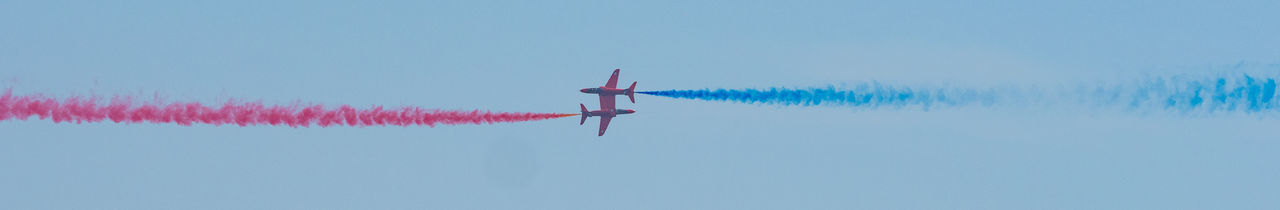 Low angle view of airplane flying against clear blue sky