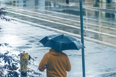 Rear view of boy holding umbrella