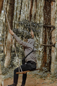 Full length of young man standing in forest