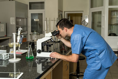 Side view of young man standing on table