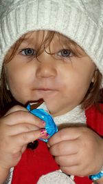 Close-up portrait of cute girl holding face