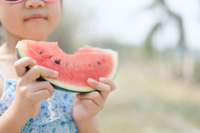 Midsection of cute girl eating watermelon