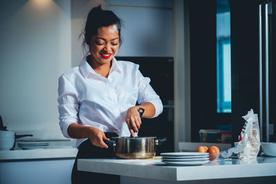 Mid adult woman standing in kitchen