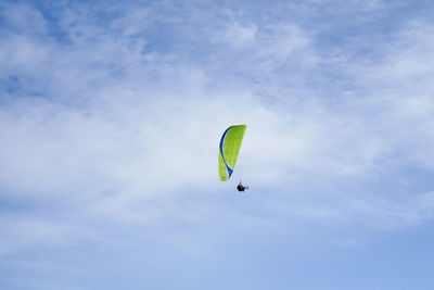 Low angle view of person paragliding against sky