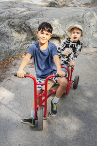 Portrait of child friends riding tricycle